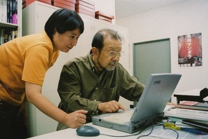 東松先生にPC作業を教える泰子さん